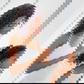 mom brushing daughters hair before head lice treatment