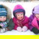 Group of children playing on snow in winter time