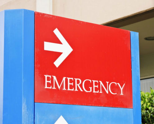 sign at the hospital points towards the emergency room entrance.