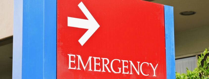 sign at the hospital points towards the emergency room entrance.