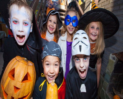 Children in halloween costumes show funny faces