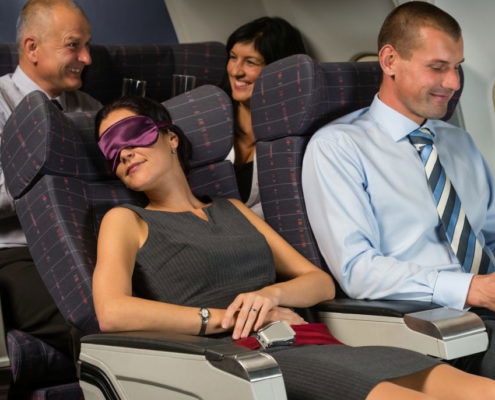 Business woman sleep during night flight airplane cabin passengers