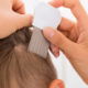Close-up Of Female Doctor performing comb treatment On Boy's Hair With Comb