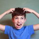 Young boy is upset he needs a head check because he may have lice wearing a blue t-shirt